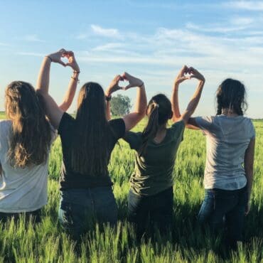 women forming heart gestures during daytime